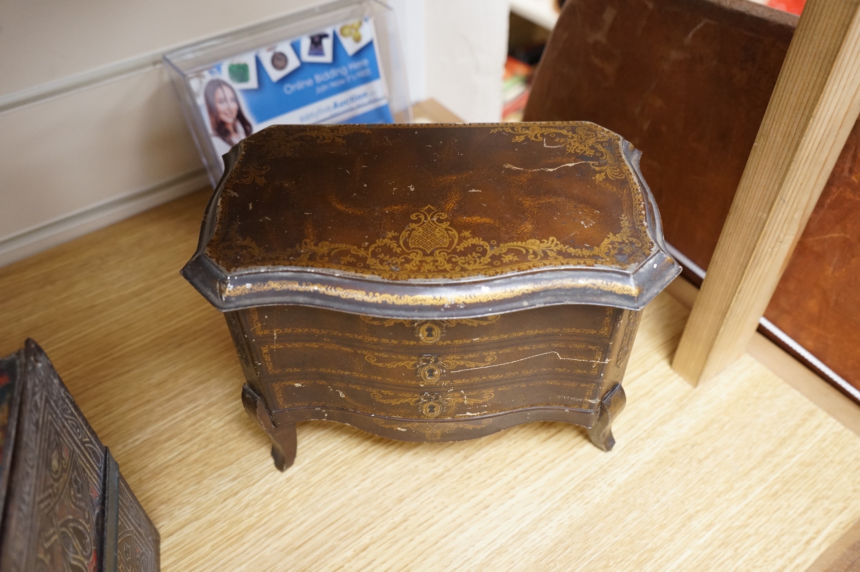 A Huntley and Palmer biscuit tin, modelled as a set of books and and two Mcvitie and Price tins modelled as French chests, tallest 16cm